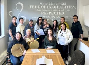Atira leadership team with the Indigenous programs team gathered together in a meeting room.