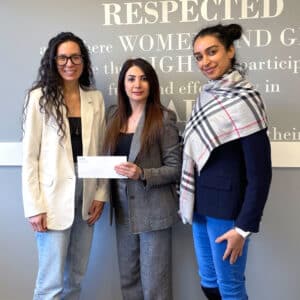 ATIRA leadership standing with a donor, symbolizing corporate giving and partnership