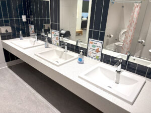 A clean and organized children’s bathroom with instructional posters showing proper handwashing techniques