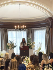 Tannaz Alesafar giving a speech at the Women of Oakwyn (WOO) event as part of a third-party fundraising initiative for ATIRA
